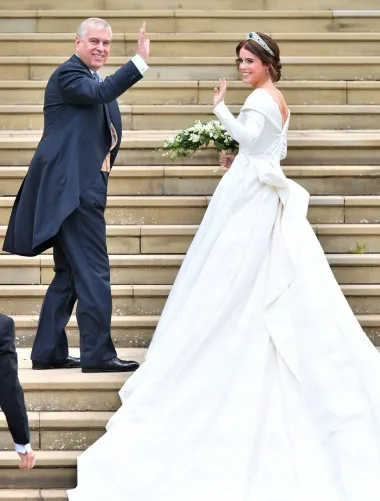 Za svoj veliki dan princeza Eugenie odabrala je raskošnu tradicionalnu vjenčanicu od svile s decentnim uzorkom, koju su imali čast dizajnirati Peter Pilotto i Christopher De Vos, kreativni dvojac koji stoji iza britanskog brenda Peter Pilotto, osnovanog 2007. godine. Slavni dvojac osmislio je za britansku princezu elegantnu i sofisticiranu haljinu s dugačkim šlepom i predimenzioniranom mašnom na leđima.