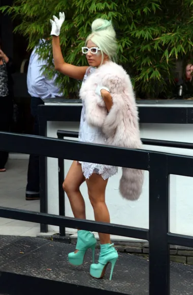 Još jedan neobičan outfit iz 2011. - ovog puta, Lady Gaga je bila u Londonu i napuštala svoj hotel i pritom mahala svojim fanovima, &quot;malim čudovištima&quot;. Na sebi je nosila bijelu čipkastu haljinu i krzno, a na nogama je nosila vrtoglavo visoke štikle u baby blue boji koje su se savršeno uklopile u njezinu boju kose.