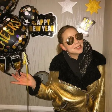 Kraljica visokih tonova, glazbena diva Mariah Carey obično je znana kao obožavateljica dubokih dekoltea i seksi haljina, no na ovoj je fotki vidimo u neobično čednom, iako šljokastom izdanju za Novu godinu. Okružena zlatnim detaljima i odjevena u zlatnu jaknu, Mariah je odala počast Novoj godini na sebi svojstven način - uz obilje zlata, glamura i luksuza. 