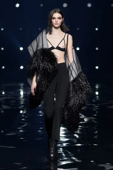 Francuska modna kuća Givenchy poznata je po genijalnim, uvijek elegantnim i chic kreacijama, a ovo je jedna od njih. Kombinacija klasičnih poslovnih hlača, neobične pelerine i prozirnog grudnjaka ostavili su sve prisutne oduševljenima. Ovaj je styling kreiran za Tjedan mode u Parizu 2021., a odisao je misterioznošću. 