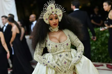 Reperica Cardi B znana je po svojim ekstravagantnim i često vrlo neobičnim fashion lookovima, a ovaj s Met Gale 2018., u kojem se pojavila u visokom stupnju trudnoće postao je jedan od najupečatljivijih te večeri. Naime, Cardi se &quot;utegnula&quot; u raskošno ukrašenu zlatnu haljinu koja je izgledala kao hibrid korzeta s plaštem i zlatnog oklopa, a sve skupa je bilo dodatno podignuto na višu razinu dubokim dekolteom i obiljem ukrasnih dragulja. Svakako outfit s crvenog tepiha koji će se dugo pamtiti. 