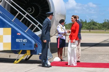Četvrtog dana putovanja, pri odlasku iz države Belize, Kate je nosila Yves Saint Laurent vintage crveni kaputić na vezanje, s džepovima i glomaznim gumbima, koji je kupila u vrijeme dok je još bila studentica. Kombinaciju je uparila s hlačama u boji slonovače s potpisom  Alexandera McQueena  i torbicom u istoj nijansi. Ovim je izborom garderobe za trenutke oproštaja vojvotkinja ponovno odala počast zastavi zemlje koju je bila posjetila. 