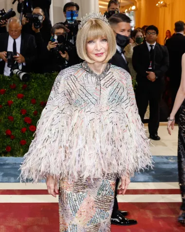 Modna urednica američkog Voguea, slavna i zloglasna Anna Wintour, na ovogodišnjoj se Met Gali pojavila u ovom neobičnom matching setu s pončom i tiarom na vrhu glave. Sve prisutne je iznenadilo što nije nosila svoje sunčane naočale, bez kojih se inače ne pojavljuje ni na jednom eventu. Kracija je inače dizajn modne kuće Chanel, a svakako izgleda raskošno i pomalo otkačeno - taman kao posveta ionako uvijek drugačijem američkom modnom izričaju. 