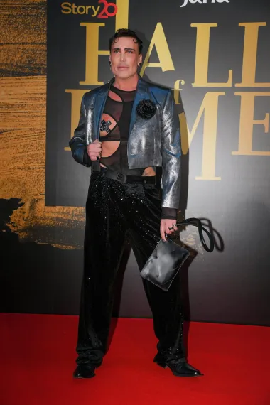Fashion stručnjak Neven Ciganović nije propustio priliku da nas iznenadi svojim lookom. Odabrao je tako za ovu svečanu priliku metalik srebrnu jaknu, a ispod koje je nosio poluprozirni crni bodi s obiljem proreza. Na taj je način istaknuo svoje isklesano tijelo i mišiće, a nije nam promaknuo ni detalj da je obojio nokte na rukama u matching srebrnu nijansu laka, koja se savršeno slagala s njegovom jaknicom. 