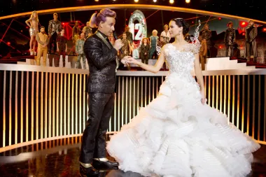 Ovu vjenčanicu, koju je nosila Jennifer Lawrence koja tumači Katniss Everdeen, kreirao je indonezijski dizajner Tex Saverio. Iako ju Katniss ne nosi dok hoda do oltara, nemoguće je zaboraviti ovu legendarnu haljinu s velikim brojem volana i futurističkim korzetom. 