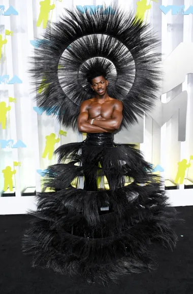 Reper Lil Nas X nije nas razočarao. I prije poznat po svojim ekstravagantnim odjevnim kombinacijama, sinoć je oduševio u kreaciji u kojoj nije mogao proći nazapaženo.Goli torzo te pernato pokrivalo za glavu i pernatom suknjom, izgledao je kao da je došao sa piste slavnih modnih revija Victoria&apos;s secreta. 