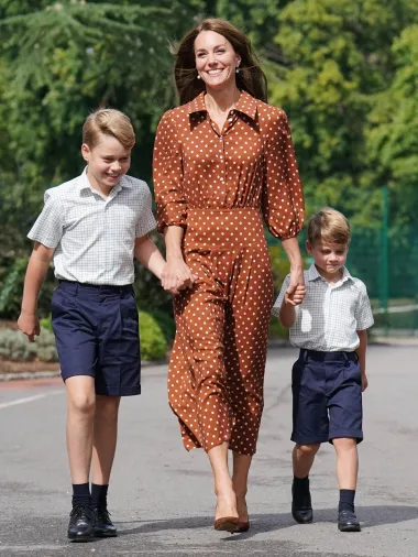 Maleni prinčevi nosili su košulje kratkih rukava s uzorkom, a mama Kate odabrala je jednostavnu, a elegantnu smeđu Rixo haljinu na točkice  a koja stoji oko 2500 kuna. Vojvotkinja se često pojavljuje u sličnim krojevima, a ovim je izborom obitelj postigla svojevrsnu modnu usklađenost. Sve je upotpunila smeđim salonkama od brušene kože s potpisom Gianvita Rossija. 