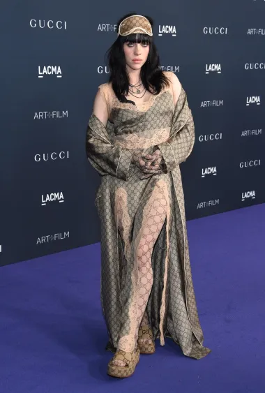 Eilish je ispod dekice,  nosila dugu slip haljinu s čipkastim rubovima te je dodala ogrtač s istim uzorkom, ali i najlon čarape. No outfit je naglasila maskom za spavanje, rukavicama, čarapama i papučama.  Duhovita ili zimogrozna? U svakom slučaju se odlučila za ležernost. 
