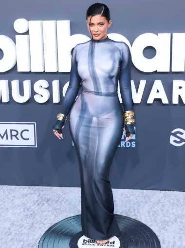 Američka manekenka i reality zvijezda Kylie Jenner na Billboardovoj dodjeli glazbenih nagrada pojavila se iznimno uskoj haljini u &apos;naked&apos; stilu modne kuće Balmain. Populprozirnu plavu metalik haljinu koja je naglasila njezine obline mankenka je začinila zlatnim nakitom i sandalama. 
