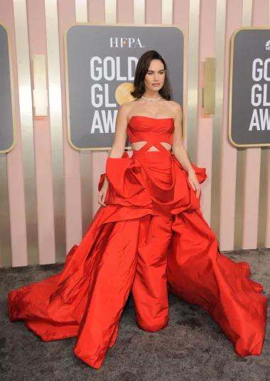 Glumica Lily James odlučila se za raskošnu crvenu haljinu iz Ateliera Versace koju je dizajnirala Dontella Versace. S jedne strane radi o klasičnom izboru za crveni tepih, ali opet ima twist zbog proreza i vrlo neobičnih nabora na donjem dijelu haljine. 
