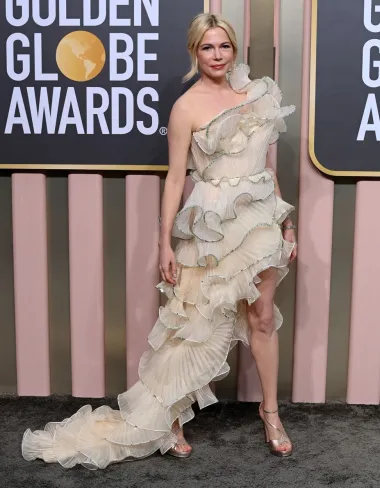 Zvijezda filma &quot;The Fabelmans&quot; koji je ove godine dobio najvažnije nagrade, Michelle Williams, odlučila se za romantičnu toaletu. Haljina u boji šampanjca na jedno rame modne kuće Gucci savršeno je pristajala njezinoj nježnoj figuri. Asimetričnu haljinu s volanima upotpunila je jednostavnom frizurom i jednostavnim zlatnim sandalama s platformama. 