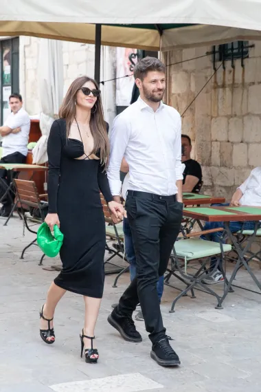 Iva Šarić i Bruno Petković bili su uzvanici na vjenčanju Adriane i Duje Ćalete-Cara u lipnju 2022., a za tu je priliku bivša manekenka odjenula crnu midi haljinu dugih rukava s riskantnim dekolteom, uz koju je kombinirala sandale na platformu Saint Laurent i zelenu Bottega Veneta torbicu.