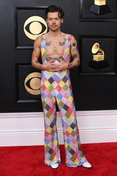 Harry Styles uvijek oduševljava svojim odvažnim modnim odabirima, a tako je bilo i ovog puta. Nosio je šareni kombinezon s dubokim izrezom brenda Egonlab, kreiran s oko 250 tisuća Swarovski kristala.
