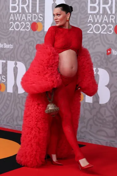 A prvi put u deset godina crvenim je tepihom na dodjeli BRIT-s prošetala i pjevačica Jessie J, koja je nosila crveni bodi od čipke s izrezom koji je otkrivao njezin trudnički trbuščić. Bodi s potpisom dizajnerice Brielle upotpunila je crvenim kaputom s volanima od tila brenda Selezza London.