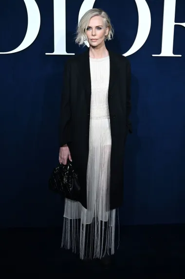 Zaštitno lice kuće Dior, Charlize Theron, došla je na modnu reviju u Pariz i pokazala kako je uvijek chic i posebna. Ovaj put je zasjala u jednostavnoj bež haljini s resicama i visokim prorezom. Outfit je upotpunila crnim jednostavnim kaputom, chunky čizmama i torbicom u istoj boji. 