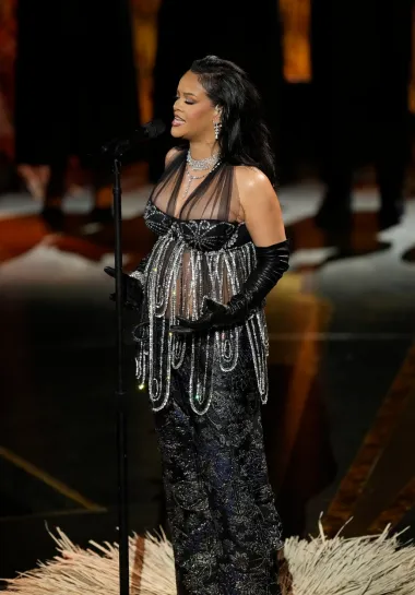 Ipak na pozornici gdje je ove godine nastupala, Rihanna je isfurala posve drugačiju kombinaciju. Hlače i majicu na bretele s puno šljokica i kristala. 