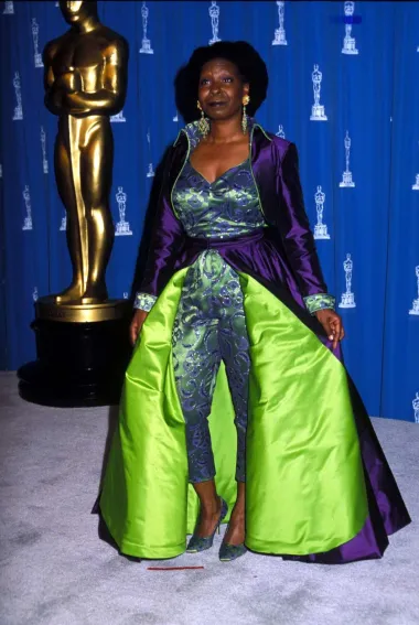 Popularna američka komičarka i glumica na dodjelu Oscara 1993. godine došla je u pomalo kontroverznom outfitu kojeg su mnogi ismijali. Whoopi se, naime, pojavila u brokatnom kombinezonu i cipelama od identične tkanine, a uz to je nosila i upečatljiv ljubičasti plašt. Iako je za mnoge ova kombinacija bila potpuni modni promašaj, ne možemo poreći da je riječ o zaista odvažnom looku.