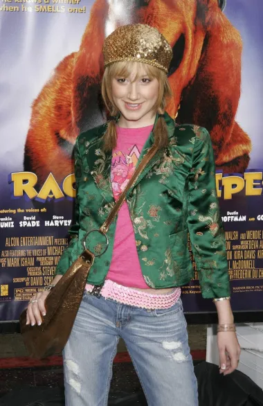 Na premijeri filma &apos;Racing Stripes&apos; 2005. godine, glumica Ashley Tisdale također se pojavila u ležernom izdanju, tipičnom za 2000. godine. Nosila je traperice niskog struka s ružičastim remenom, ružičastu majicu i cvjetni zeleni sako, a od modnih dodataka odabrala je zlatnu šljokičastu kapu i zlatnu torbu preko tijela.