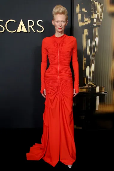 Tilda Swinton poznata je po svojem otkačenom i ekscentričnom stilu, a za ovu prigodu odabrala je dugačku usku crvenu haljinu s naborima. Tilda je poznata po svojim neobičnim frizurama, a ovog puta nije napravila izuzetak. Skupila je svoju plavu kosu u rep, što je izdužilo njeno lice. 