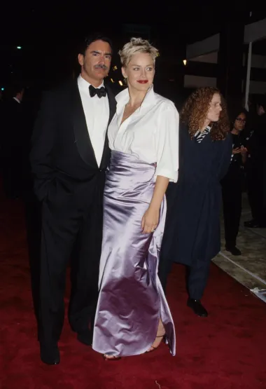 &quot;Sharon Stone nije nosila haljinu na dodjeli Oscara 1998. godine, ali je definitivno imala upečatljiv izgled. Klasičnu bijelu košulju na kopčanje iz Gapa spojila je s elegantnom svilenom suknjom Vere Wang. No, s gotovo potpuno otkopčanim gumbima i lagano podignutim ovratnikom, stvorila je modni trenutak iz devedesetih koji i danas živi na mood boardovima dizajnera i stilista.&quot; 
