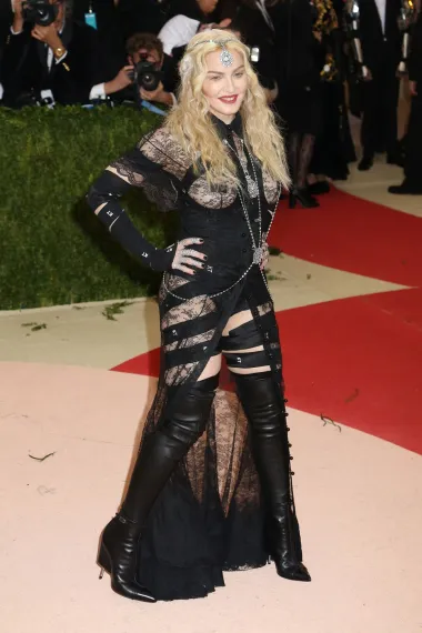 Madonna je na crvenom tepihu Met Gale s temom Manus x Machina: Moda u doba tehnologije otkrila gotovo sve – u outfitu inspiriranom bondage estetikom, koji je uključivao Givenchyjevo tange-body odijelo, čipkaste draperije, kožne čizme do bedara, nakit za tijelo i izreze oko grudi. 