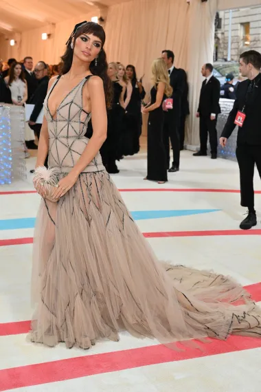 Emily Ratajkowski nosila je eteričnu haljinu s dubokim dekolteom brenda Tory Burch, koju je krasio geometrijski uzorak na korzetu i izraženi izrez.