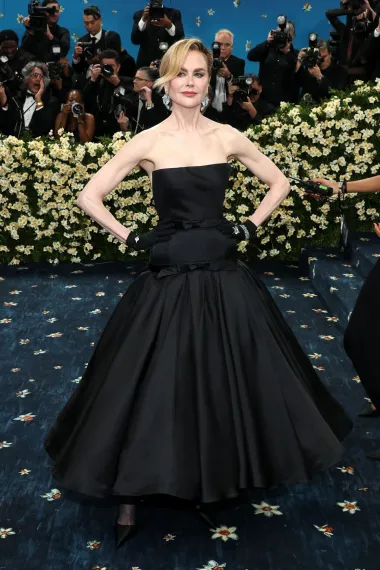 Nicole u voluminozno krojenoj Balenciaga haljini iz 1952. godine. Haljina je zahtijevala 700 sati ručnog rada i uključivala korzet od svilenog organza, svilenkaste mašne i detalje poput picot rubova, stvarajući dramatičnu i skulpturalnu siluetu. Kidman je upotpunila svoj izgled crnim čipkastim šalom, dugim rukavicama, crnim satenskim štiklama i dijamantnom nakitom.