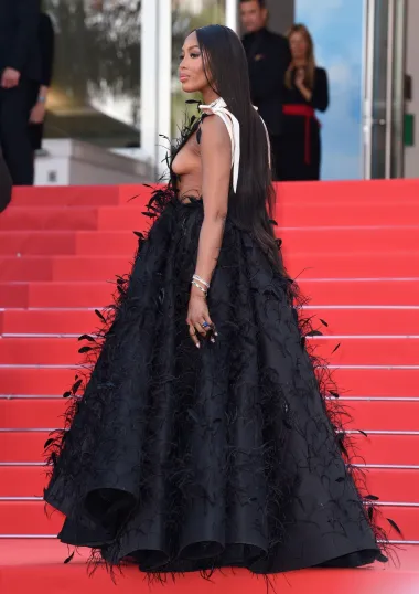 Duboki dekolte haljine Naomi Campbell, koju potpisuje Valentino, možda je bio najupečatljiviji element kroja, no ručno ušivana pera donijela su dozu prave drame. Haljina je preuzeta s modne piste Valentinove haute couture revije, a ono što joj je nedostajalo u smjeloj boji, nadoknadila je upečatljivim detaljima.